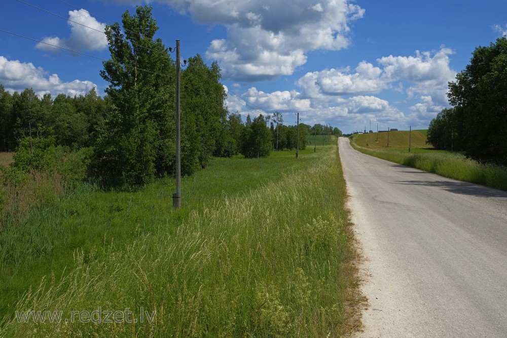 Vasaras ainava ar gubumākoņiem