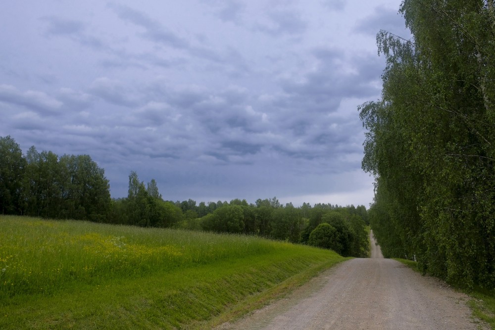 Tumši mākoņi, grantēts lauku ceļš