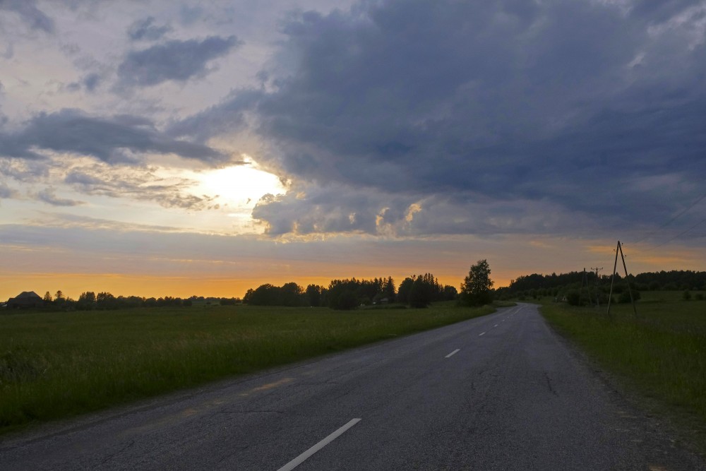 Tuvojas saulriets, tumšas vakara debesis
