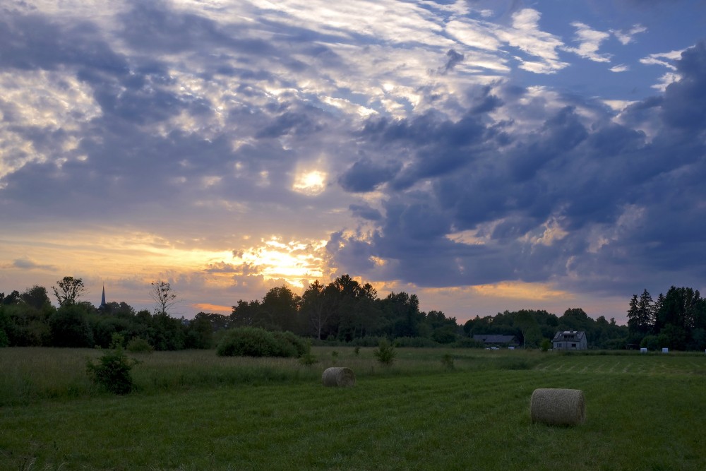 Saulriets Ugālē, mākoņainas debesis