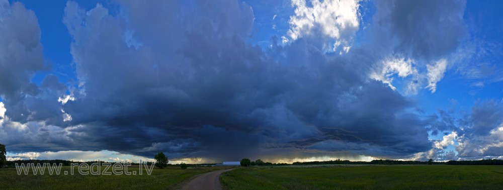 Panorāmas ainava ar lietus mākoņiem