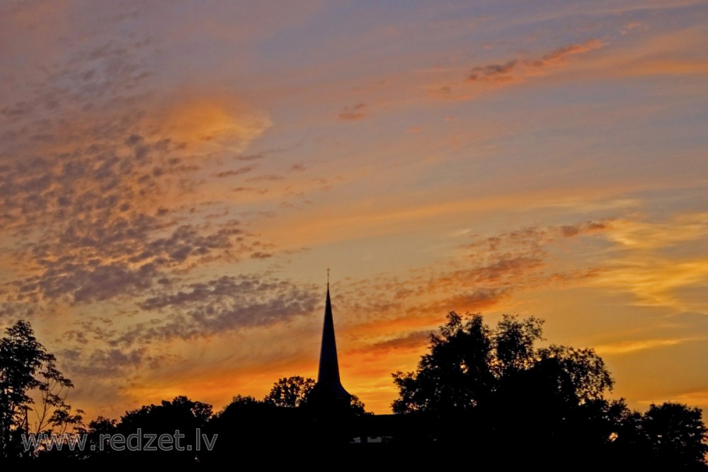 Ugāles baznīcas siluets saulrietā