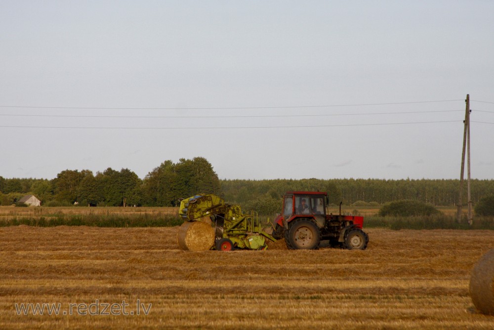 Round Baler compressing a Straw