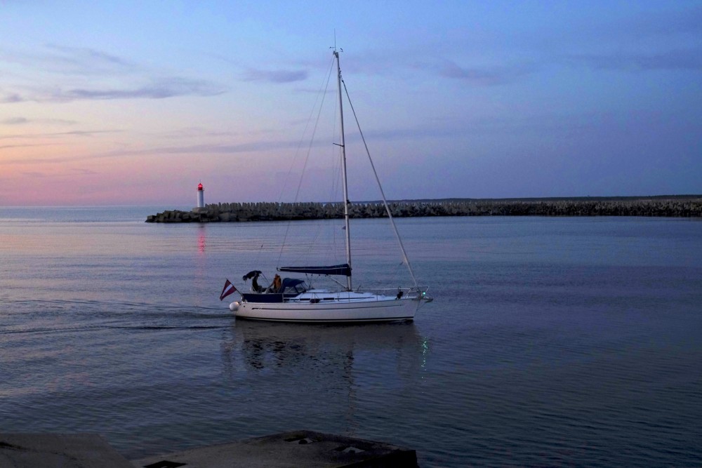 Jahta pie Ventspils ziemeļu mola vakara krēslā