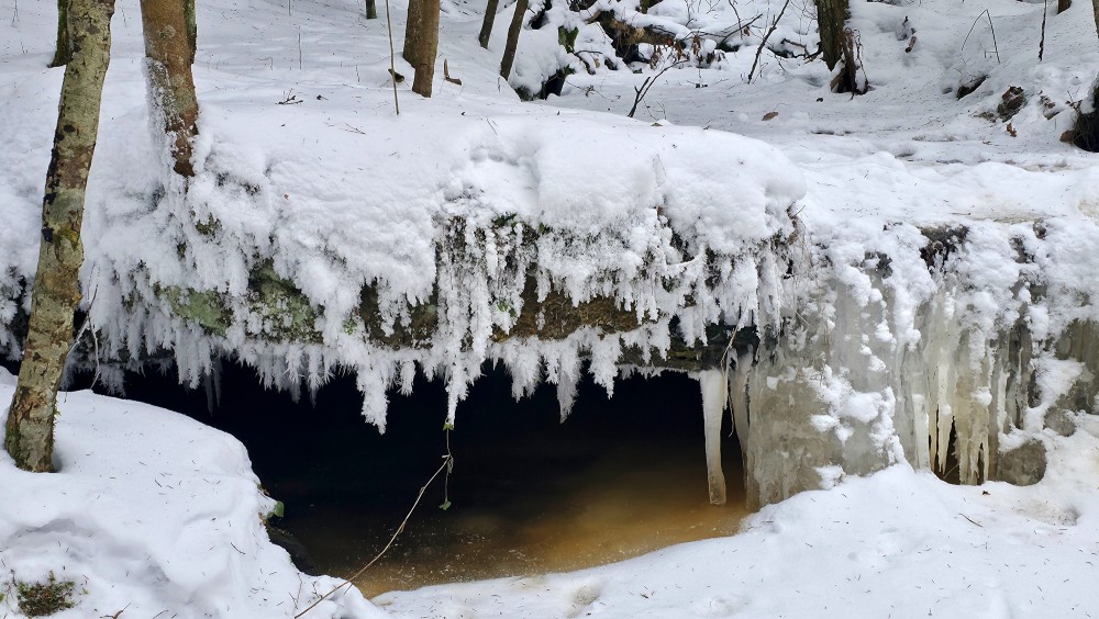 Frozen niche of the Oļupīte waterfall with icicles
