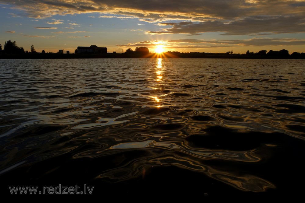 Saulrieta gaismas atspīdums Daugavas viļņos