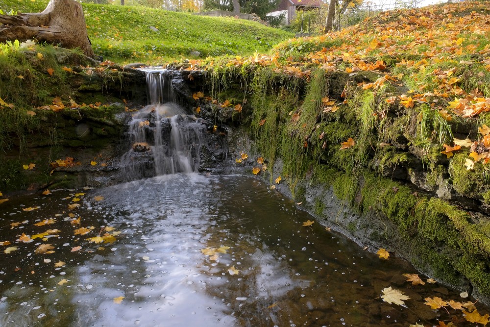 Rumbiņas ūdenskritums ar sūnām un rudens lapām