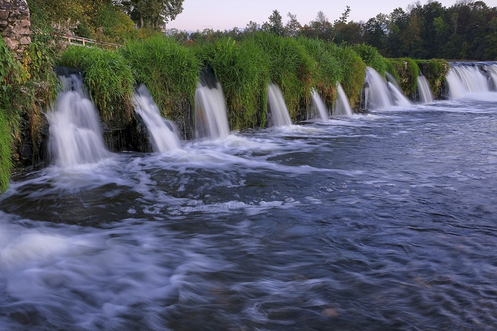 Ventas rumba ar vienmērīgām ūdens straumēm pie zālainā krasta