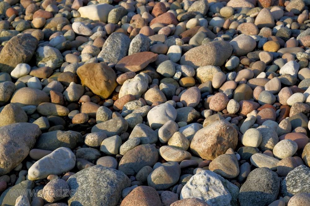 Akmeņi un oļi jūras krastā
