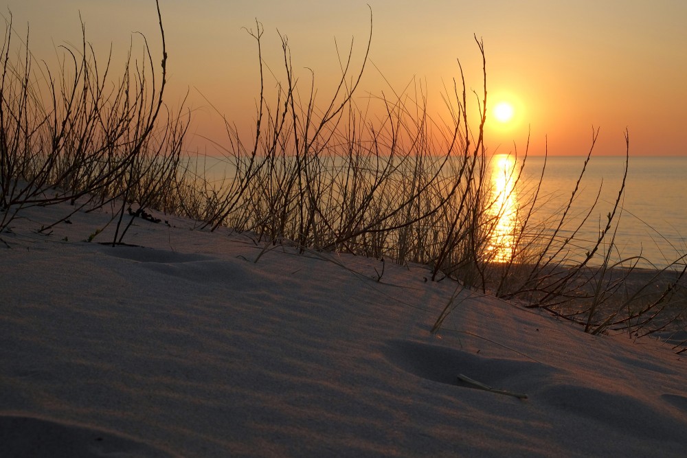 Skats uz saulrietu jūrā no kāpām