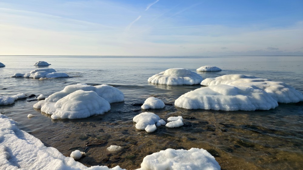 Icy rocks in clear seawater on the Užava coast
