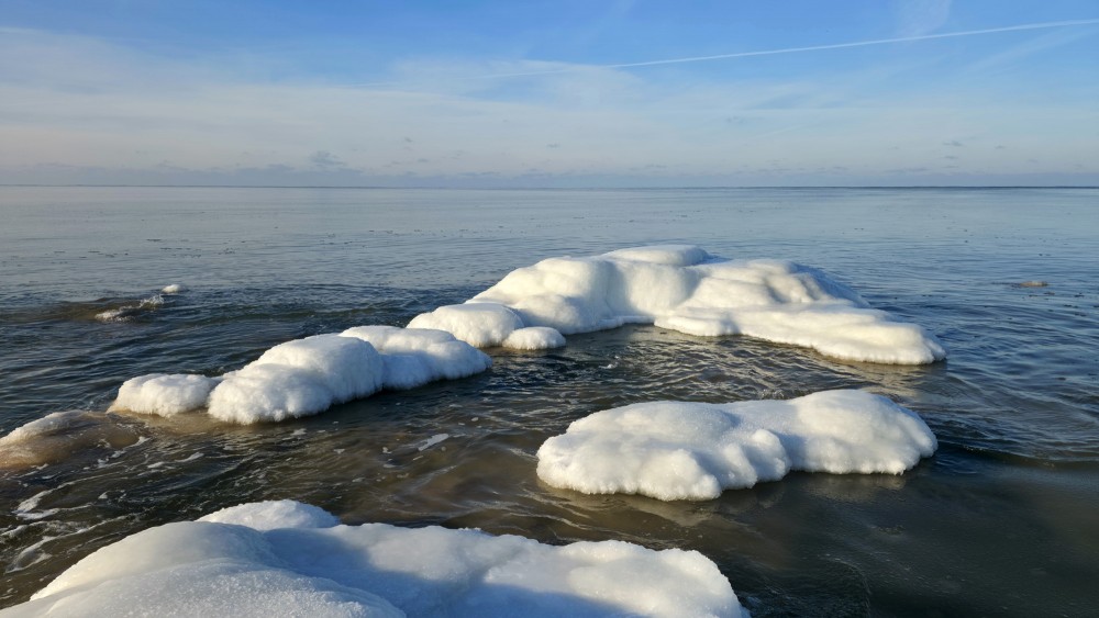 Apledojuši akmeņi un balti ledus krāvumi Užavas pludmales piekrastē