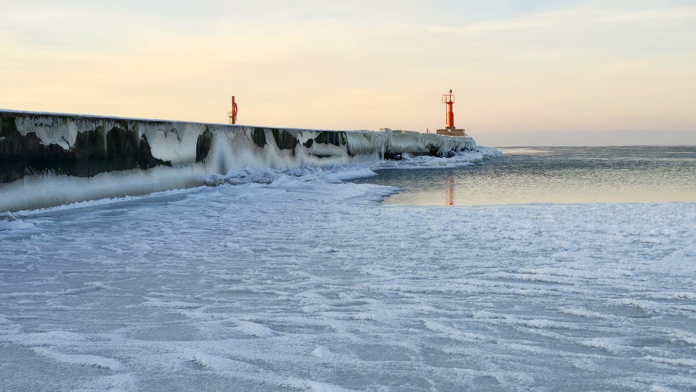 Pavilosta pier in winter with icicles and lighthouse