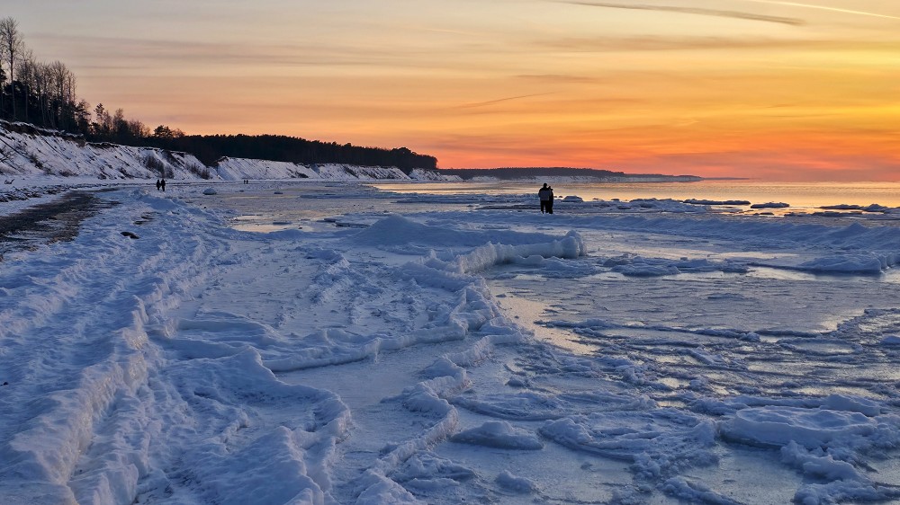 Saulriets virs sasalušā Jūrkalnes stāvkrasta un ledus krāvumiem