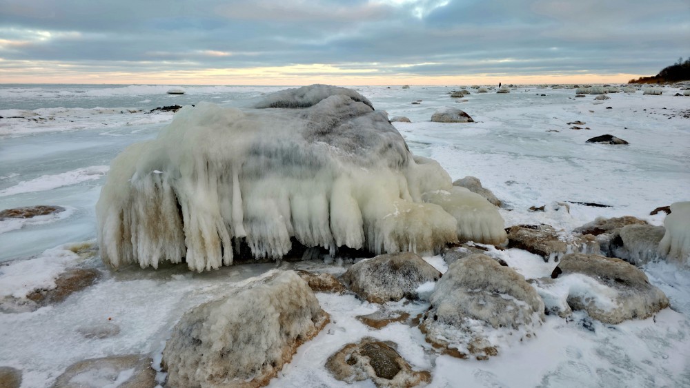 Massive icy rock on the Mērsrags coast on a winter evening