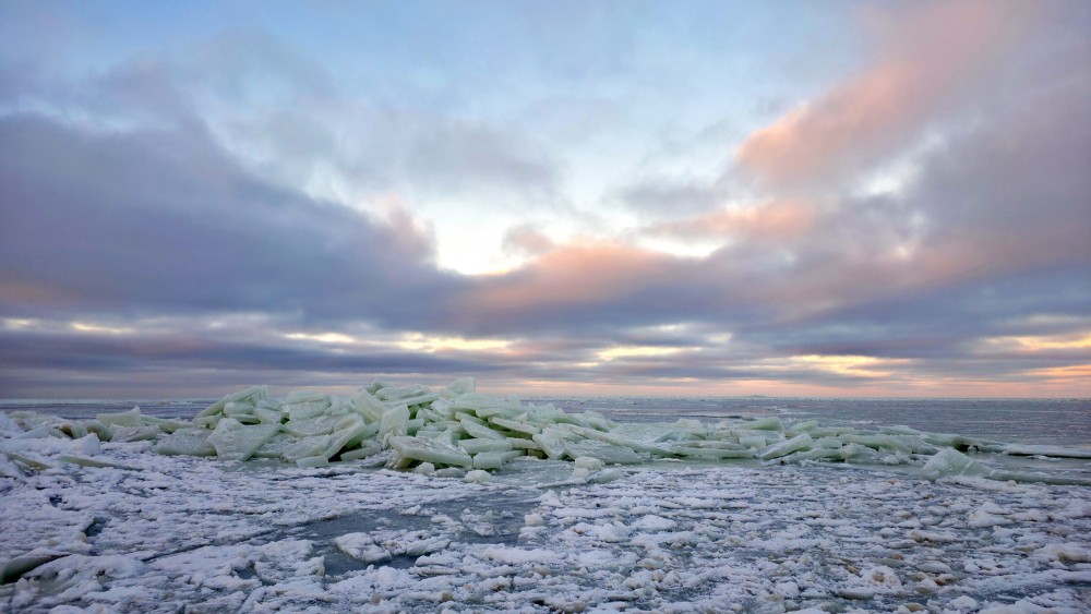 Ledus krāvumi Rīgas jūras līča piekrastē saulrieta laikā
