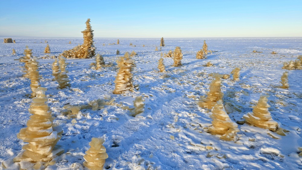 Creative ice plate towers on the wintry Bigauņciems Beach