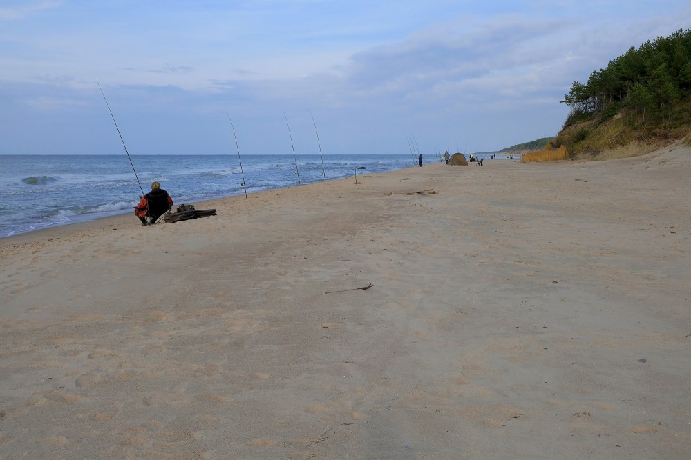 Makšķernieki jūras krastā