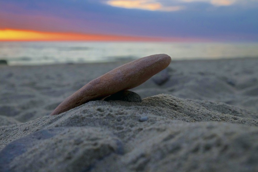 Sarkans akmens pludmales smiltīs