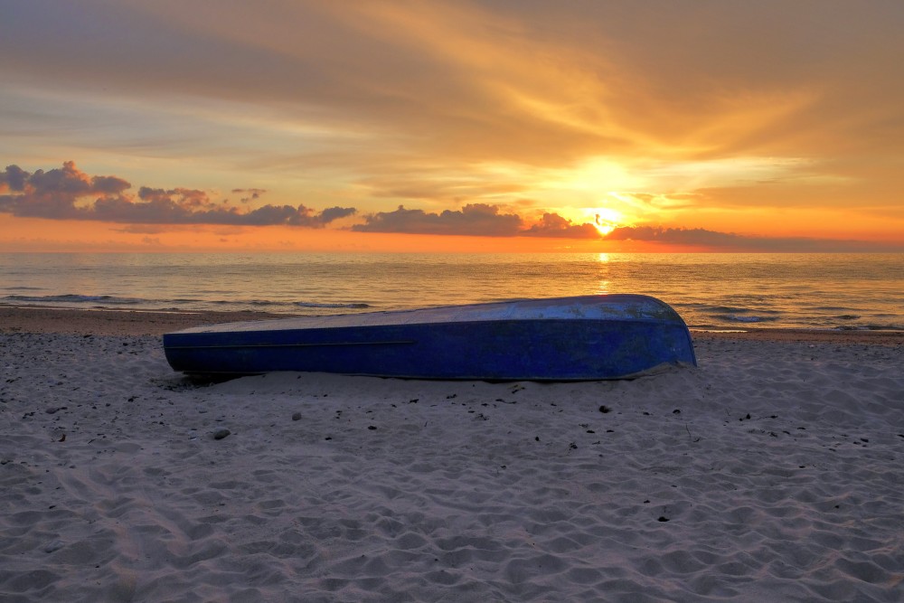 Laiva pludmalē saulrietā