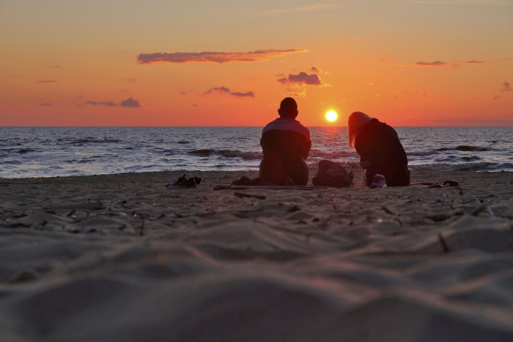 Pāris saulrietā jūrmalā