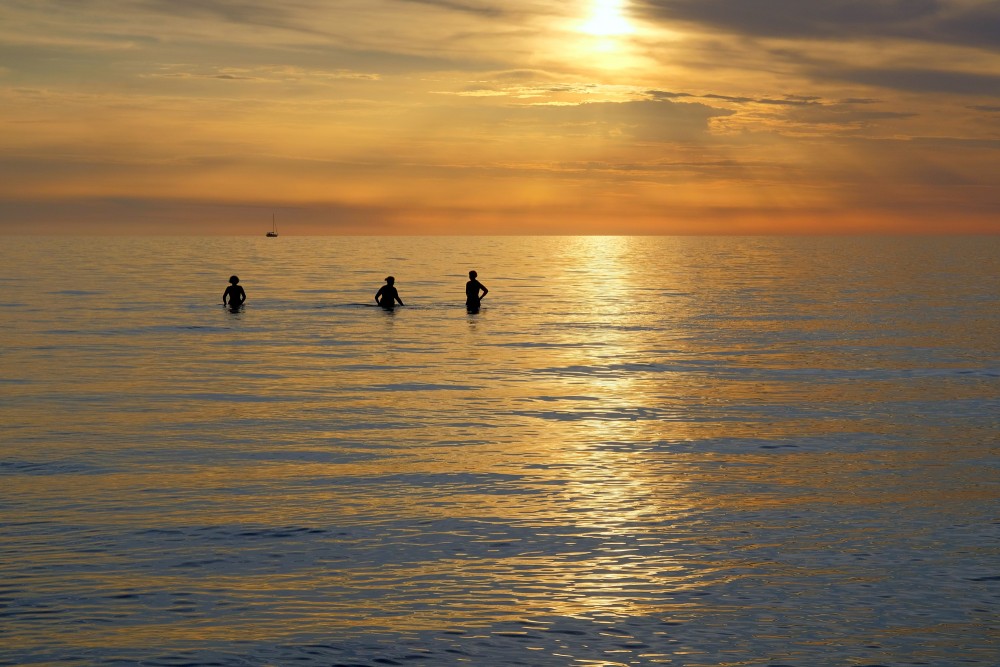 Saulriets Baltijas jūrā, cilvēku silueti