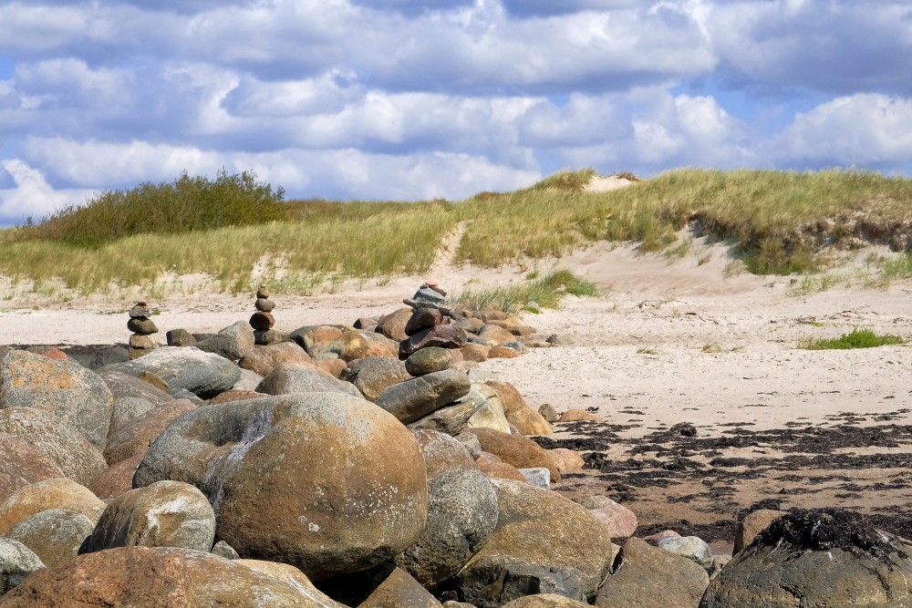 Akmeņains krasta posms ar smilšu kāpām Papes pludmalē