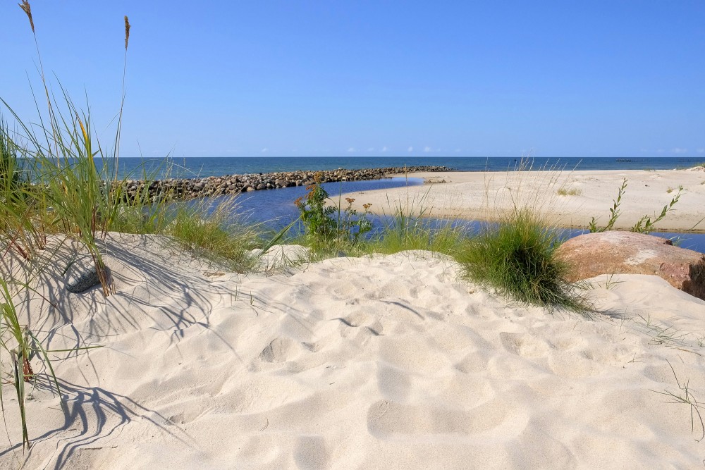 Smilšainas kāpas ar zāli pie Papes kanāla un akmens mola