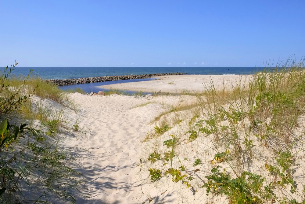 Sandy dunes and Pape Canal by the sea on a calm summer day