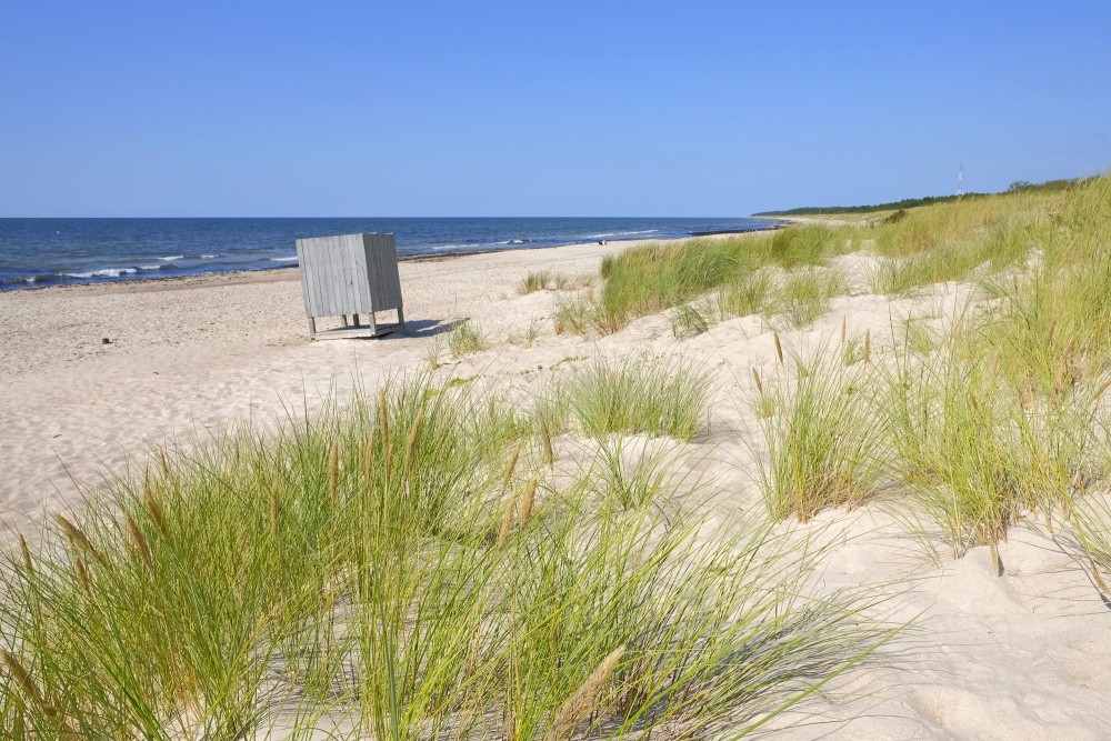 Saulaina Jūrmalciema pludmale ar pārģērbšanās kabīni un kāpām