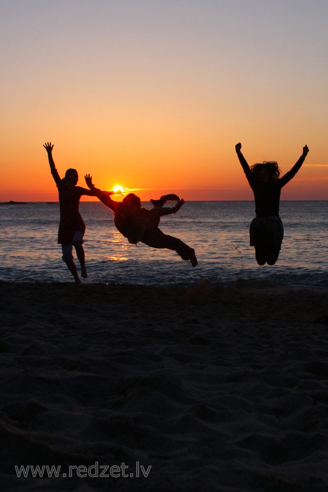 Group of People Jumping at Sunset