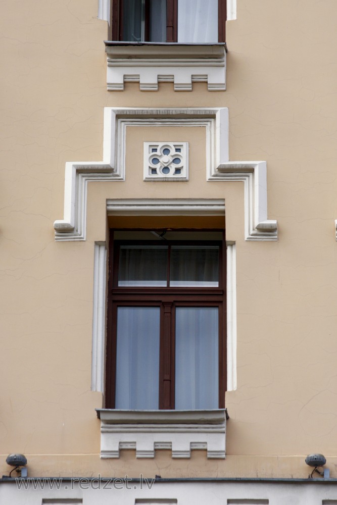 Logs ēkas fasādē (Merķeļa 12)