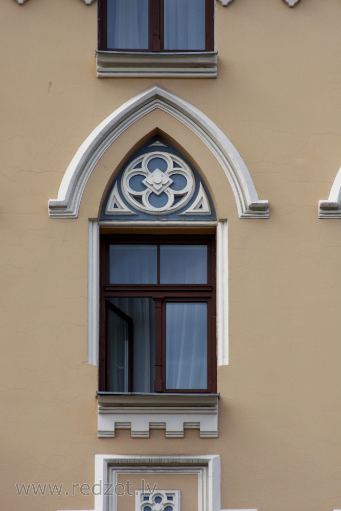 Logs ēkas fasādē (Merķeļa 12)