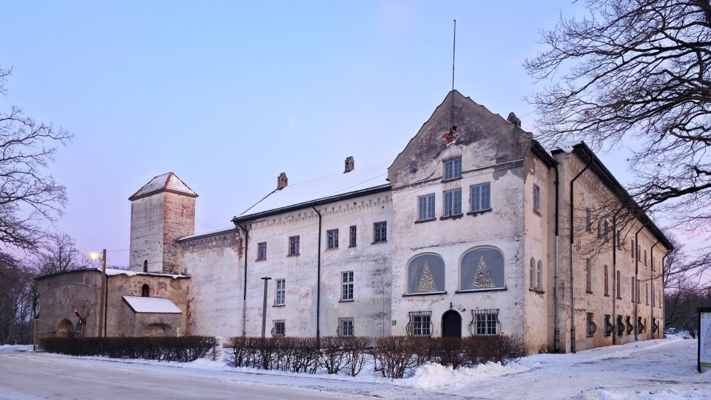 Dundaga Castle facade in winter with snow and lit windows
