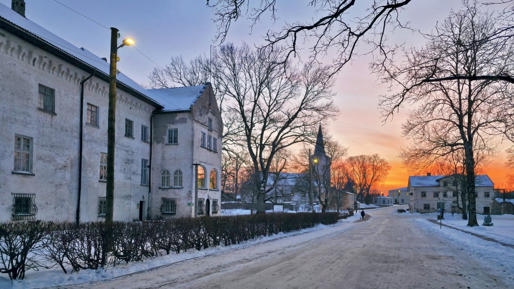 Winter street by Dundaga Castle at sunset with church tower in the distance