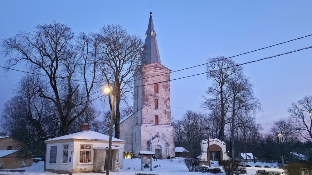 Dundagas luterāņu baznīca ziemā ar torni, sniegu un vakara apgaismojumu
