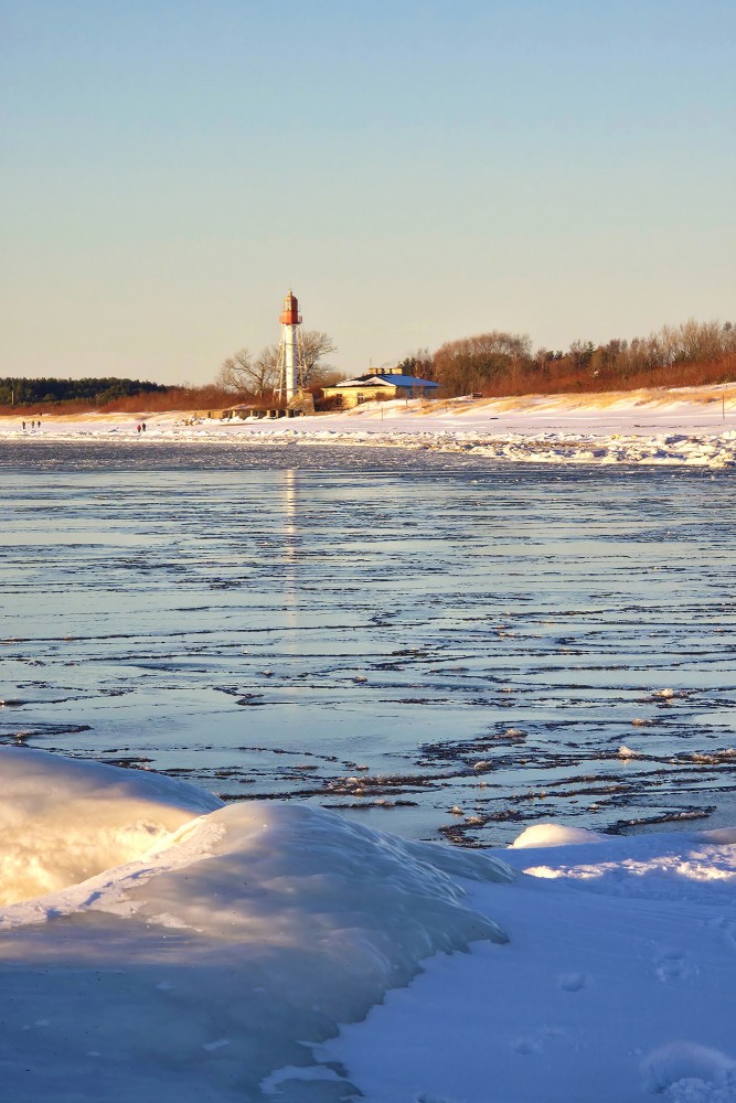 Pape lighthouse behind the ice cover of the frozen Baltic Sea
