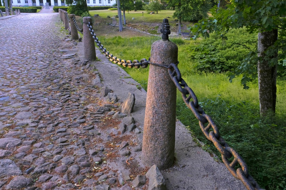 Granīta stabiņi ar dzelzs ķēdēm un rotājumiem (Kazdangas akmens tilts)