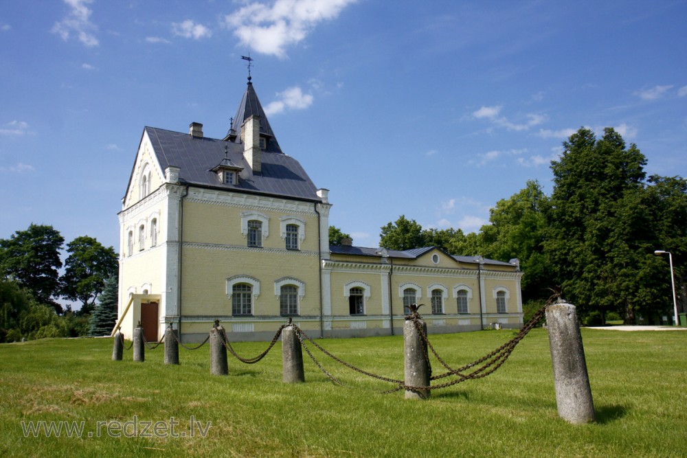 Side view of the Dole Manor house with a historic chain fence on the lawn