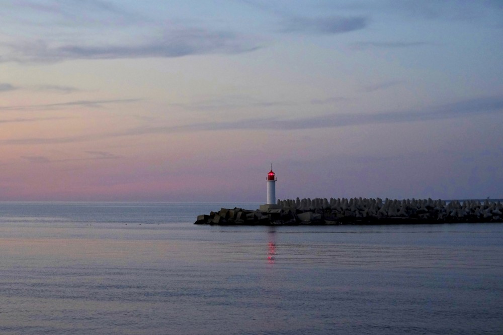 Saulrieta gaisma pie Ventspils ziemeļu mola bākas pie Baltijas jūras