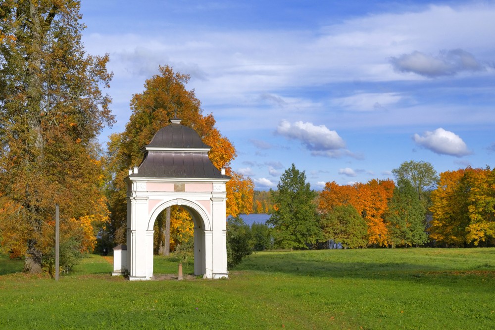 Lindes muižas vārti rudenīgā Lindes parkā ar skatu uz upi