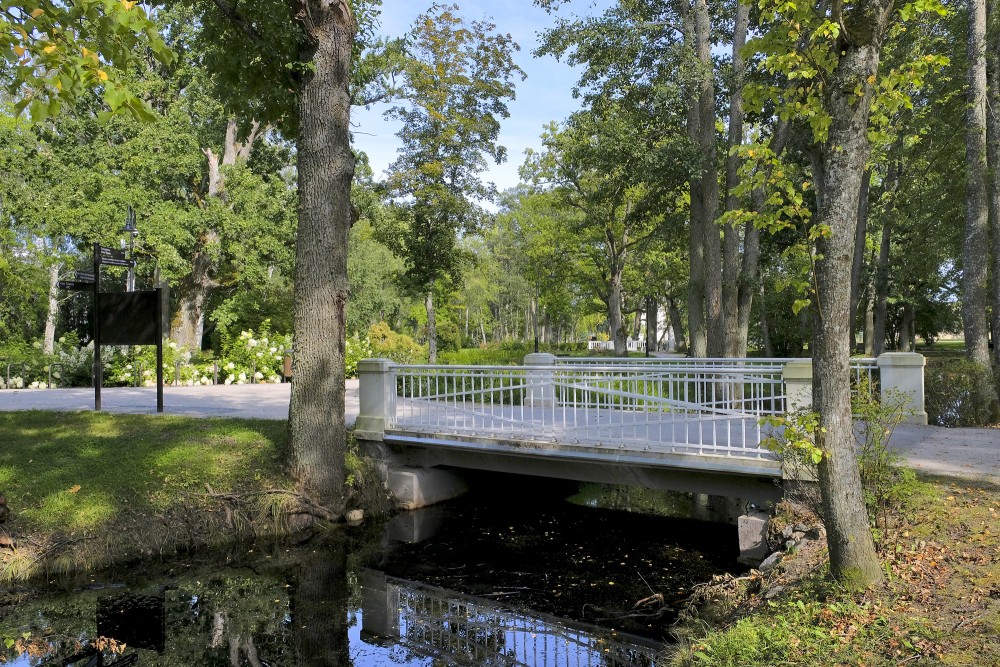 Balts tiltiņš Ķemeru kūrorta parkā starp kokiem