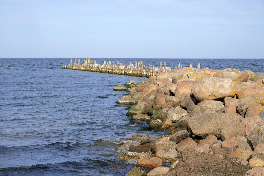 Engures mola akmeņainais krasts un vecie koka pāļi pie jūras