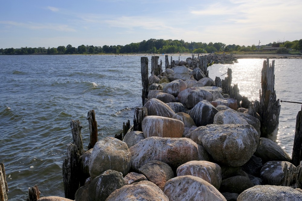 Akmens mols un piekrastes ainava saulainā dienā