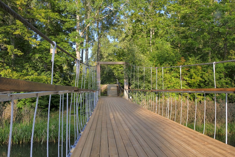 Pedestrian suspension bridge over the Saka River in Pavilosta on a sunny summer day