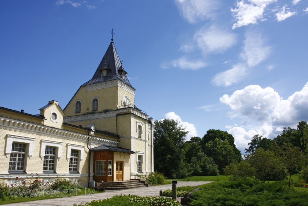 Dole Manor house facade with a tower and main entrance on a summer day