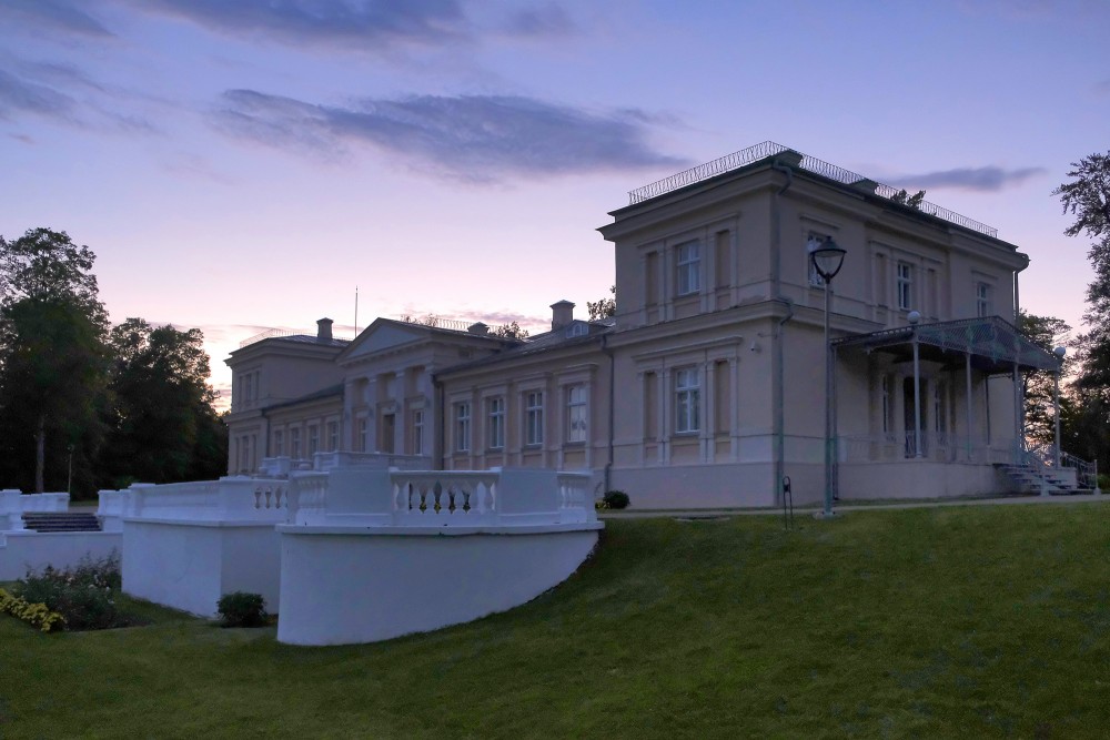 Renavas muižas kungu māja saulrieta gaismā ar terasi un parka ainavu