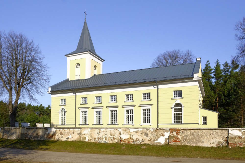 Būtiņģes evaņģēliski luteriskā baznīca ar simetrisku fasādi saulainā dienā