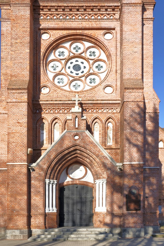 Palanga church entrance with brick arch and rose window on the facade