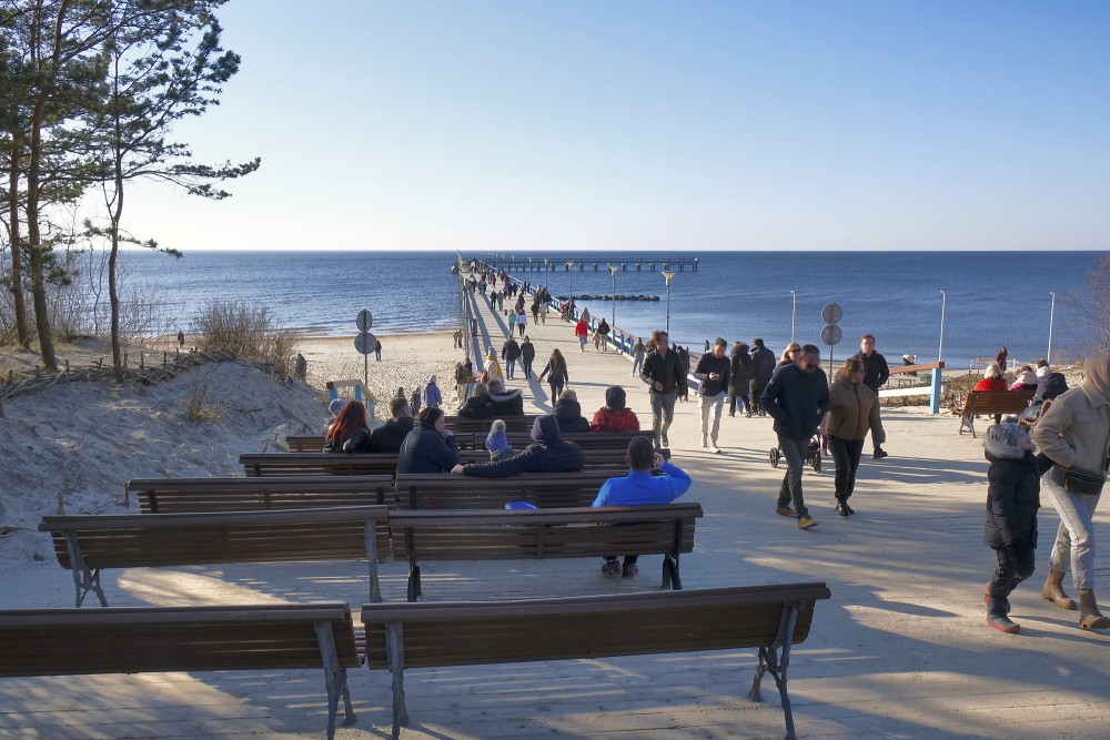 Palanga Sea Pier promenade with people and benches by the sea
